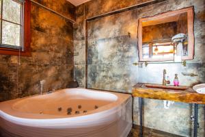 a bathroom with a tub and a sink at Keyif Motel in Faralya