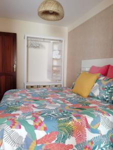 um quarto com uma cama com um edredão colorido em Nautilus I: Casa con terraza y vistas al mar em La Caleta