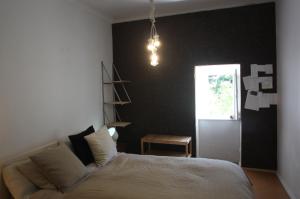 a bedroom with a bed and a black wall at ribeira dos marinheiros vermelho in Sintra