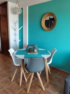 a dining room with a blue wall and a table and chairs at Nautilus I: Casa con terraza y vistas al mar in La Caleta