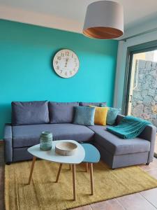 a living room with a couch and a clock on the wall at Nautilus I: Casa con terraza y vistas al mar in La Caleta