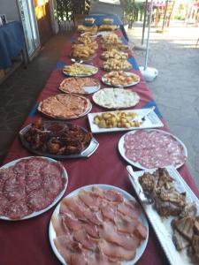 a long table with plates of different types of food at La Palazzina in Chiusdino