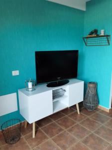 a flat screen tv on a white cabinet in a room at Nautilus I: Casa con terraza y vistas al mar in La Caleta