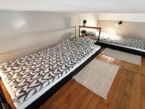 two beds in a room with wooden floors at Studio Krakow old town apartment in Krakow