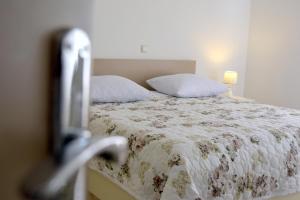 1 Schlafzimmer mit einem Bett mit Blumenbettdecke in der Unterkunft James Bond Apartments in Rab