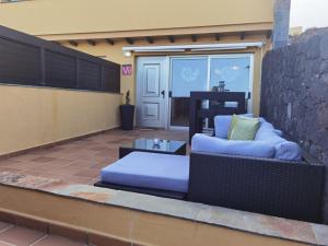 a patio with two blue pillows on top of a house at Nautilus I: Casa con terraza y vistas al mar in La Caleta