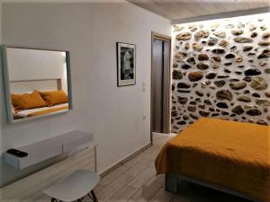 a bedroom with a bed and a mirror on the wall at The Little Gem Under The Rocks 2 in Kastraki