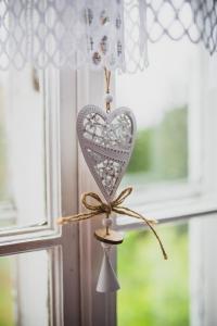 a heart ornament hanging from a window at Turnovská chata in Kořenov