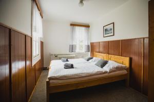 Schlafzimmer mit einem großen Bett mit einem Kopfteil aus Holz in der Unterkunft Turnovská chata in Kořenov