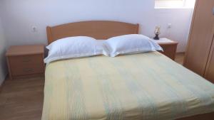 ein Schlafzimmer mit einem Bett mit zwei Kissen in der Unterkunft Lastovo City Center in Lastovo