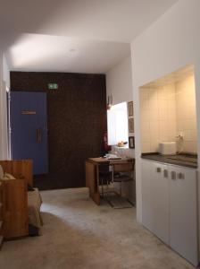 a kitchen with a table and a blue door and a desk at ribeira dos marinheiros azul in Sintra
