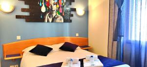 a bedroom with a bed with two tables in it at Hotel La Bosselle in Saint-Philbert-de-Grand-Lieu