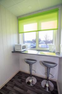a kitchen with two stools in front of a window at Vetesina in Pärnu