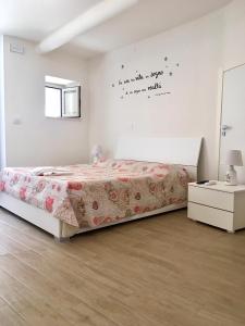a white bedroom with a bed and a window at B&B San Giovanni in Lamezia Terme