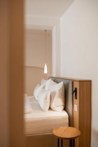 メラーノにあるKuntino Suitesのベッドルーム1室(白い枕とテーブル付)
