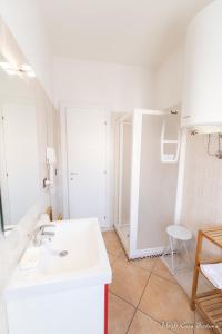 bagno bianco con lavandino e specchio di B&B Casa Fortuna a Lecco