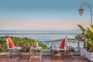 Dos sillas y una mesa en un balcón con vista. en Hotel Continental, en Taormina