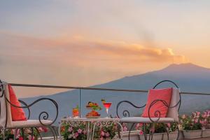 タオルミーナにあるホテル コンチネンタルの山の景色を望むテーブルと椅子