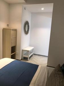 a bedroom with a bed and a white wall at Appartamento in Villa in Ginosa Marina