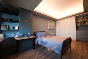 a bedroom with a bed and a desk and a chair at Ken's Joy Inn in Kaohsiung