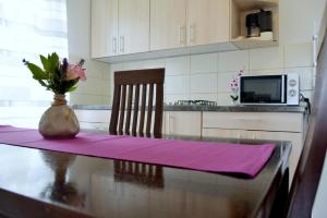 eine Küche mit einem Tisch und einer Blumenvase darauf in der Unterkunft James Bond Apartments in Rab