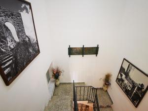 una escalera con 2 sillas y cuadros en la pared en Centro Sicilia Rooms-Suites & Terrace, en Enna