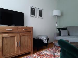 ein Wohnzimmer mit einem Flachbild-TV auf einem Holzschrank in der Unterkunft Ferienwohnung Kommunikation 5 in Brandenburg an der Havel