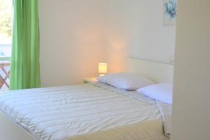 ein Schlafzimmer mit einem Bett und ein Fenster mit einer Lampe in der Unterkunft James Bond Apartments in Rab