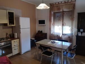 kuchnia ze stołem i białą lodówką w obiekcie Da Nonna Stella w mieście Miglianico +9 zdjęć
