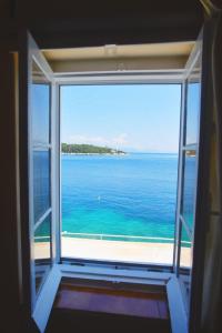 uma vista para o oceano a partir de uma janela em Efi's Cottage by the sea em Fiskardo
