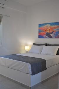 a bedroom with a large bed with a painting on the wall at Villa Konstantinos in Perissa