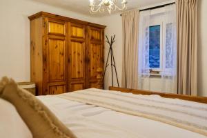 1 dormitorio con cama, ventana y lámpara de araña en Apartment Danielsbergblick, en Napplach