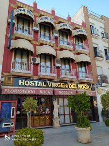 een hotel in een stad met een standbeeld ervoor bij Hostal Virgen Del Rocio in Los Palacios y Villafranca