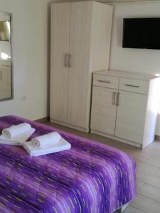 ein Schlafzimmer mit einem lila Bett mit Handtüchern darauf in der Unterkunft Apartman Studio Lu in Nerezine