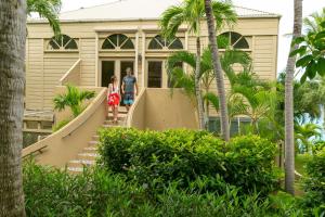 Un homme et une femme marchent par un escalier devant une maison dans l'établissement Gallows Point Resort, à Saint John