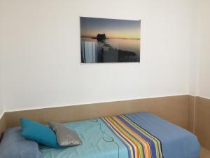 una cama en una habitación con un cuadro en la pared en Piso centrico cerca del puerto, en Sant Carles de la Ràpita