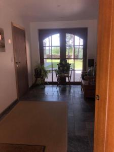 un couloir avec une porte s'ouvrant sur un salon dans l'établissement Le Goupil, à Wavre