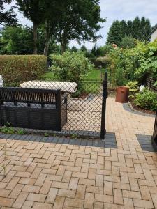 a fence with a bench in a garden at Puppenstube mit 2 Zimmern in Witten