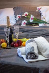 a bed with a tray of fruit and a bottle of champagne at Vila Aleka in Nei Poroi