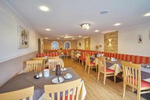 a restaurant with tables and chairs in a room at Voglöder Hof in Bad Füssing