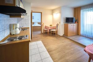 a kitchen and living room with a table and a room at Voglöder Hof in Bad Füssing +24 photos