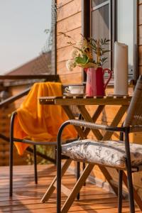 a wooden table with a vase of flowers on a patio at Guest House Usadba in Stenino