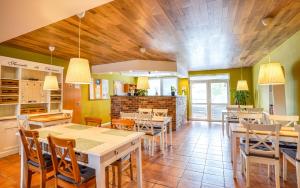 a restaurant with tables and chairs in a room at Apartmány Karmon Park in Veľký Meder