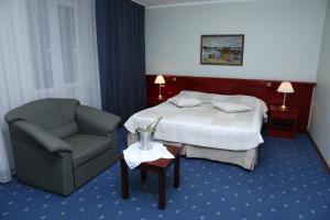 En eller flere senge i et værelse på Draakon Hotel