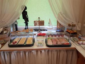 a table topped with trays of food on a table at Villa Pod Dębem in Łeba