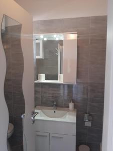 La salle de bains est pourvue d'un lavabo et d'un miroir. dans l'établissement Apartment Enis, à Barbariga