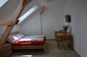 a bedroom with a bed and a table with a tv at Penzion v rodinném vinařství Kadubcovi in Lipov