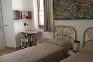 a room with two beds and a table and a window at VelaLatina Residence B&B Soverato in Soverato Marina