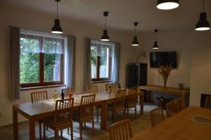 a dining room with a table and chairs and windows at Penzion v rodinném vinařství Kadubcovi in Lipov