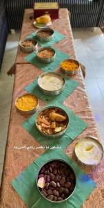 a long table with many bowls of food on it at Happiness Farm in Hatta